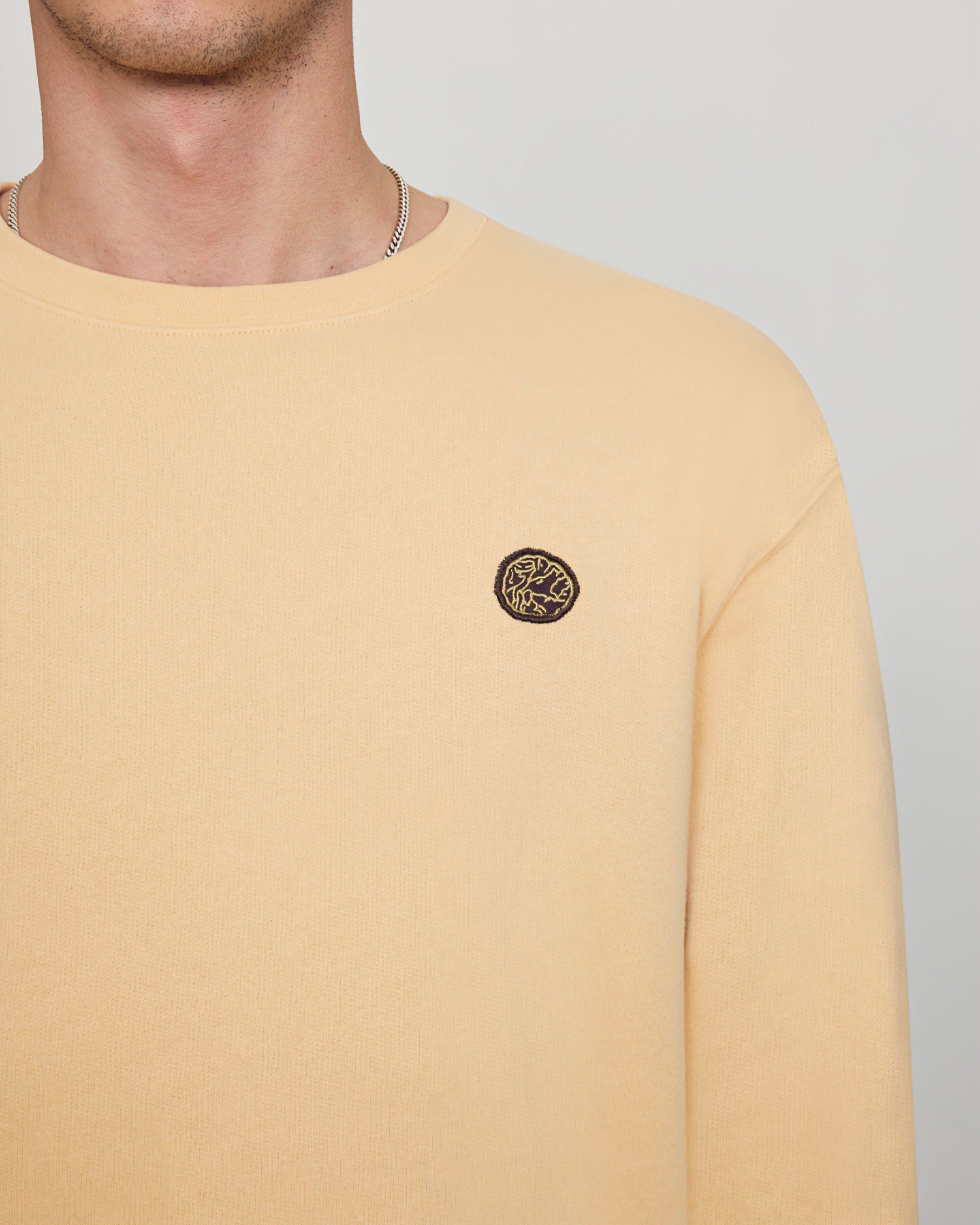 Savoj men’s emblem patch sweatshirt in soft apricot with ribbed edges