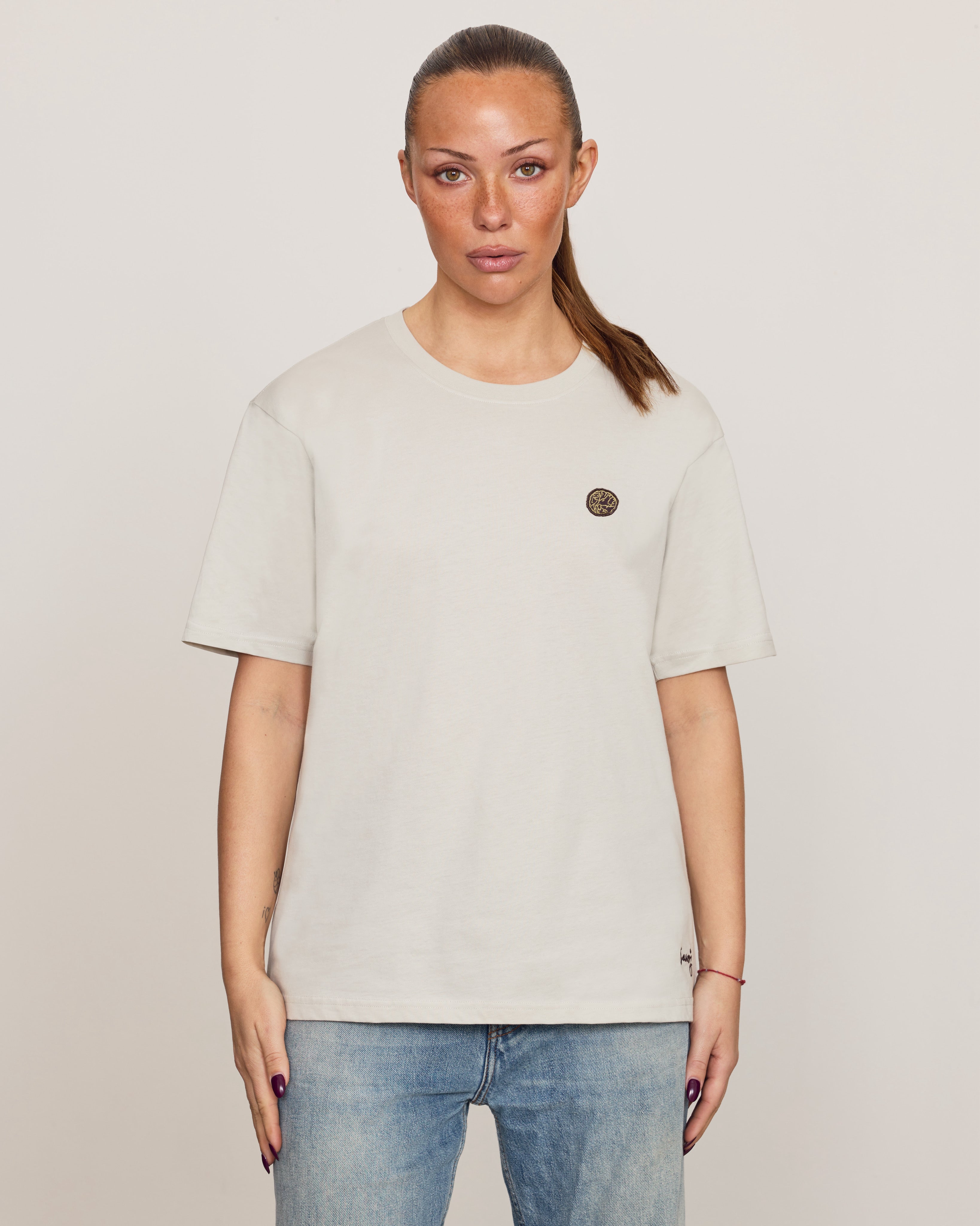 Female model wearing Unisex Savoj Egyptian Cotton Tee – Front View in Oatmilk White